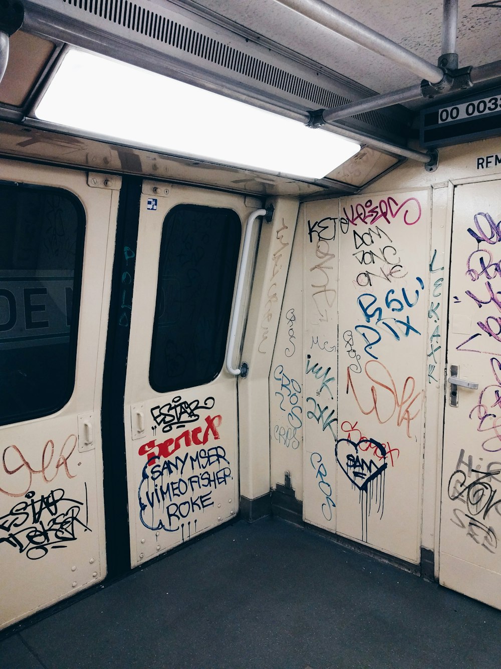 a group of white doors covered in graffiti