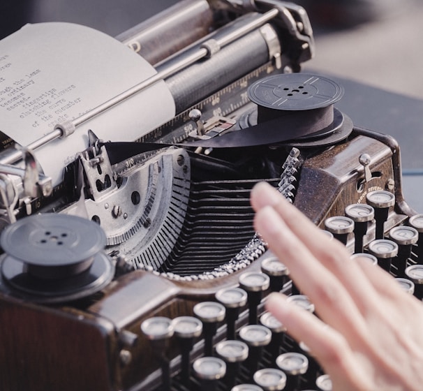 person typing using typewriter