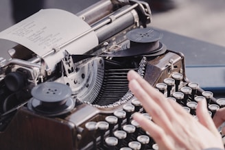 person typing using typewriter