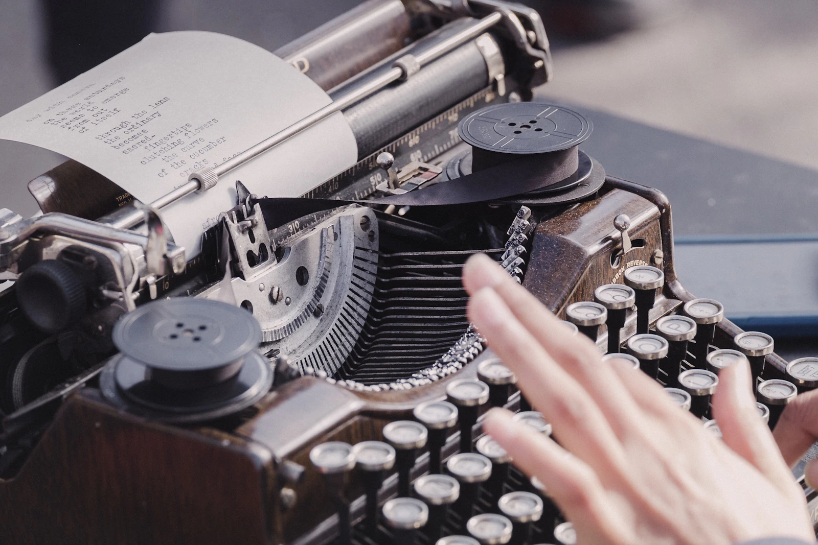 Hands typing on a typewriter.