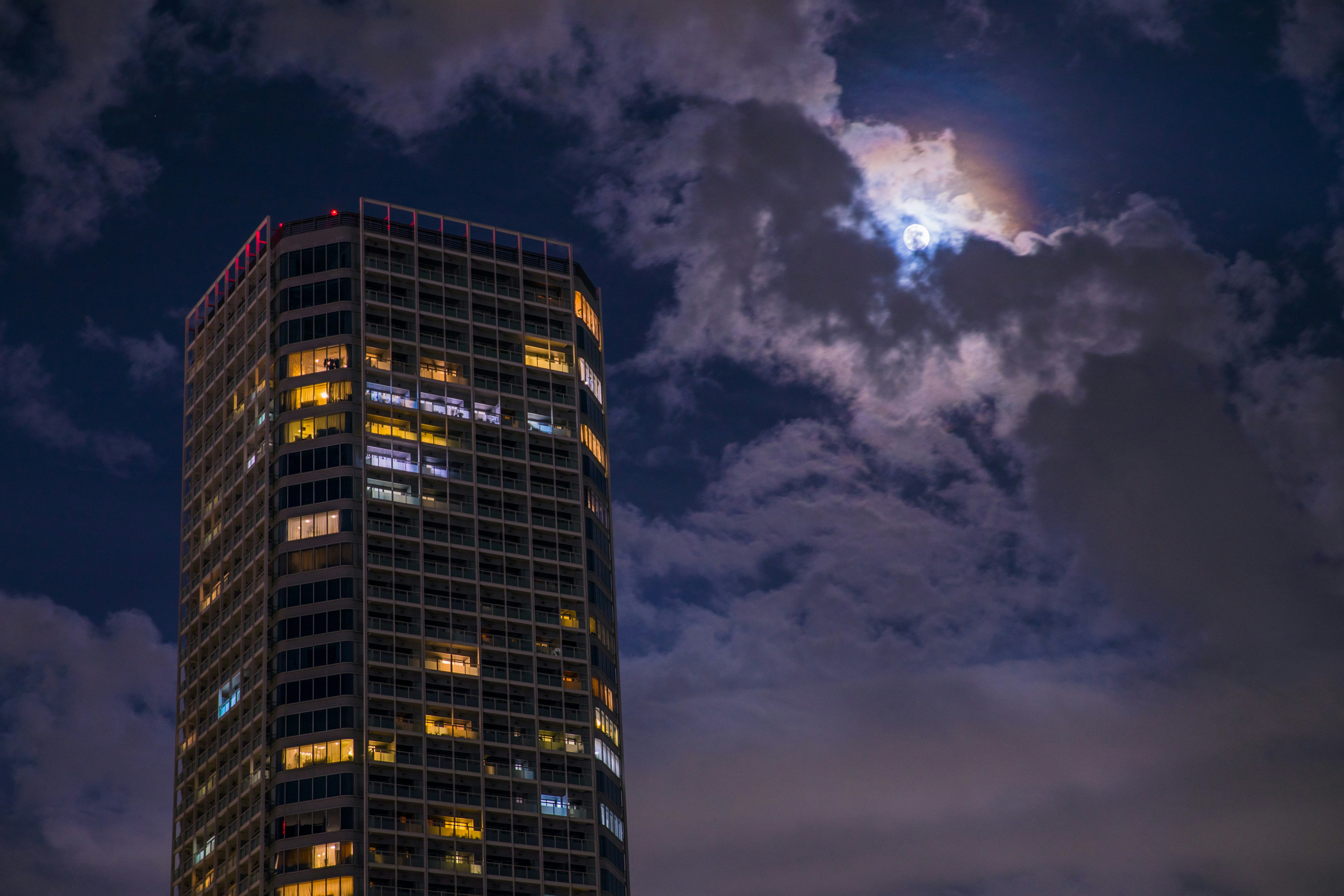 high rise building under cumulus clouds