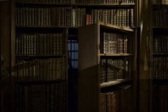 A mysterious, dimly lit room with ancient books and symbols related to the Illuminati.