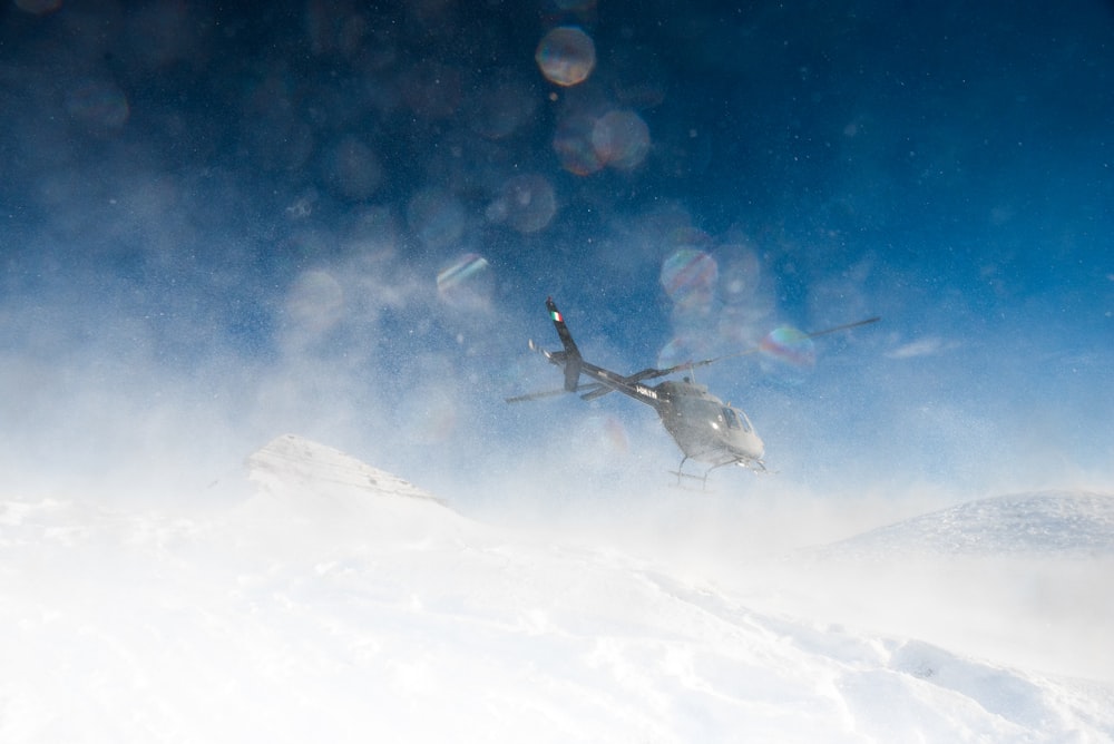 helicóptero flotando sobre la nieve