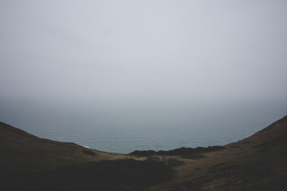 aerial photography of hill and body of water