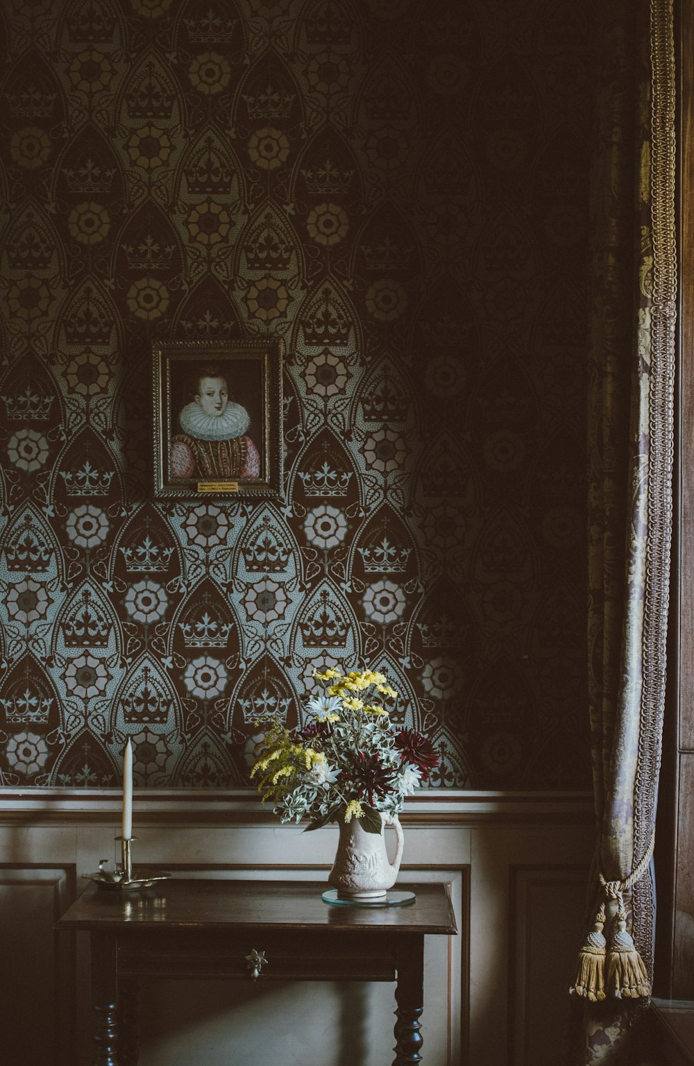 peinture accrochée au mur au-dessus de l’arrangement floral sur la table console
