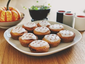 A smiling home baker arranging freshly baked cupcakes on a rustic wooden table.