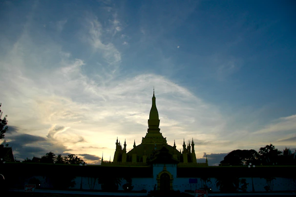 The majestic silhouette of a temple spire against a soft pastel sunset.