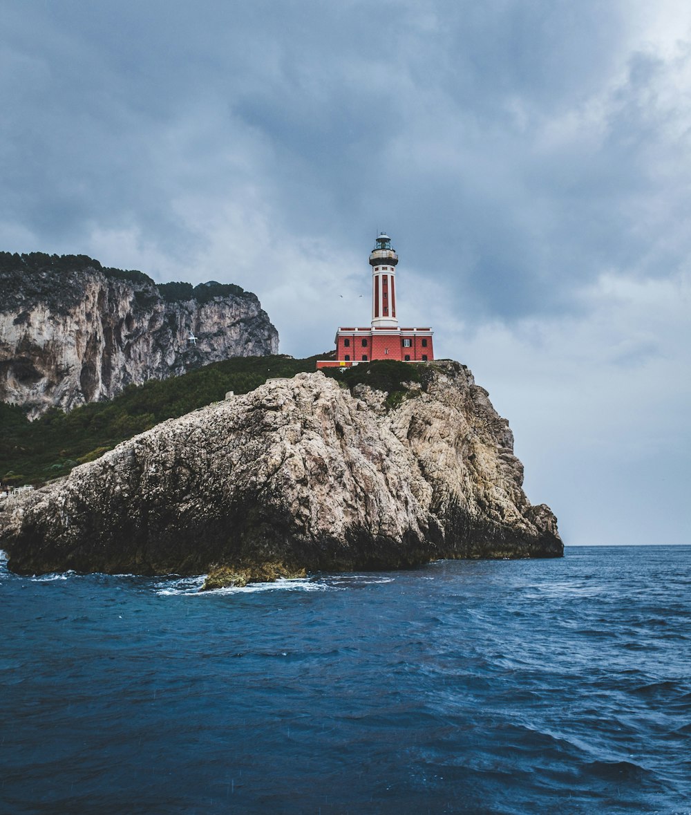 white and red lighthouse near sea shore