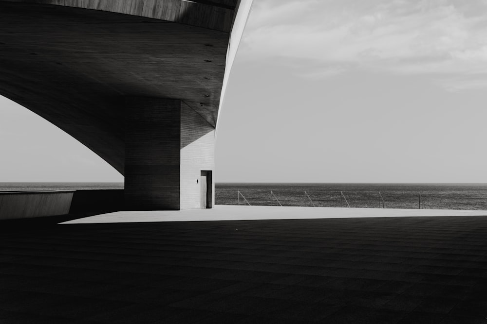 a black and white photo of a bridge over water