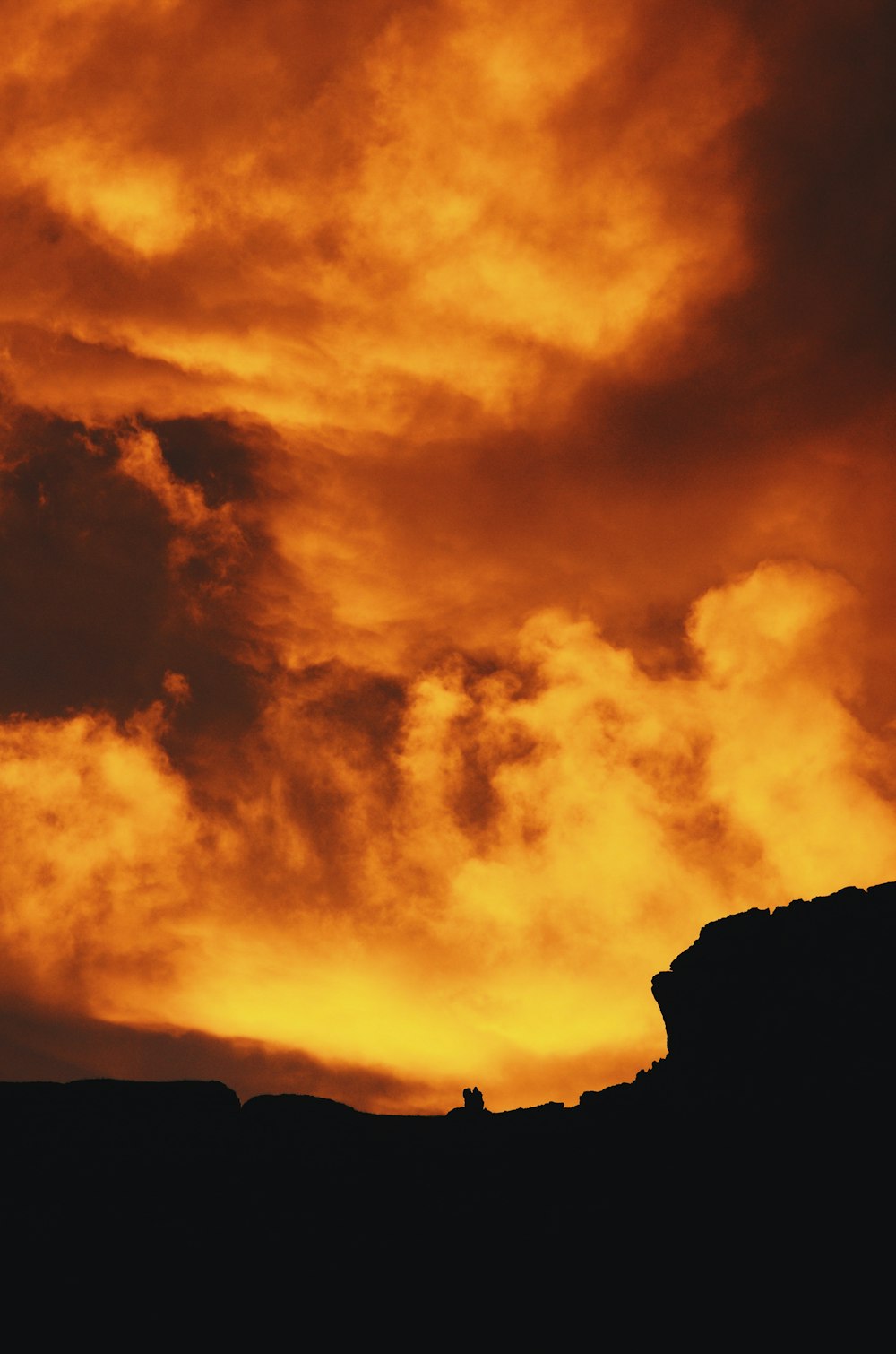 silhouette photography of hill under red sky