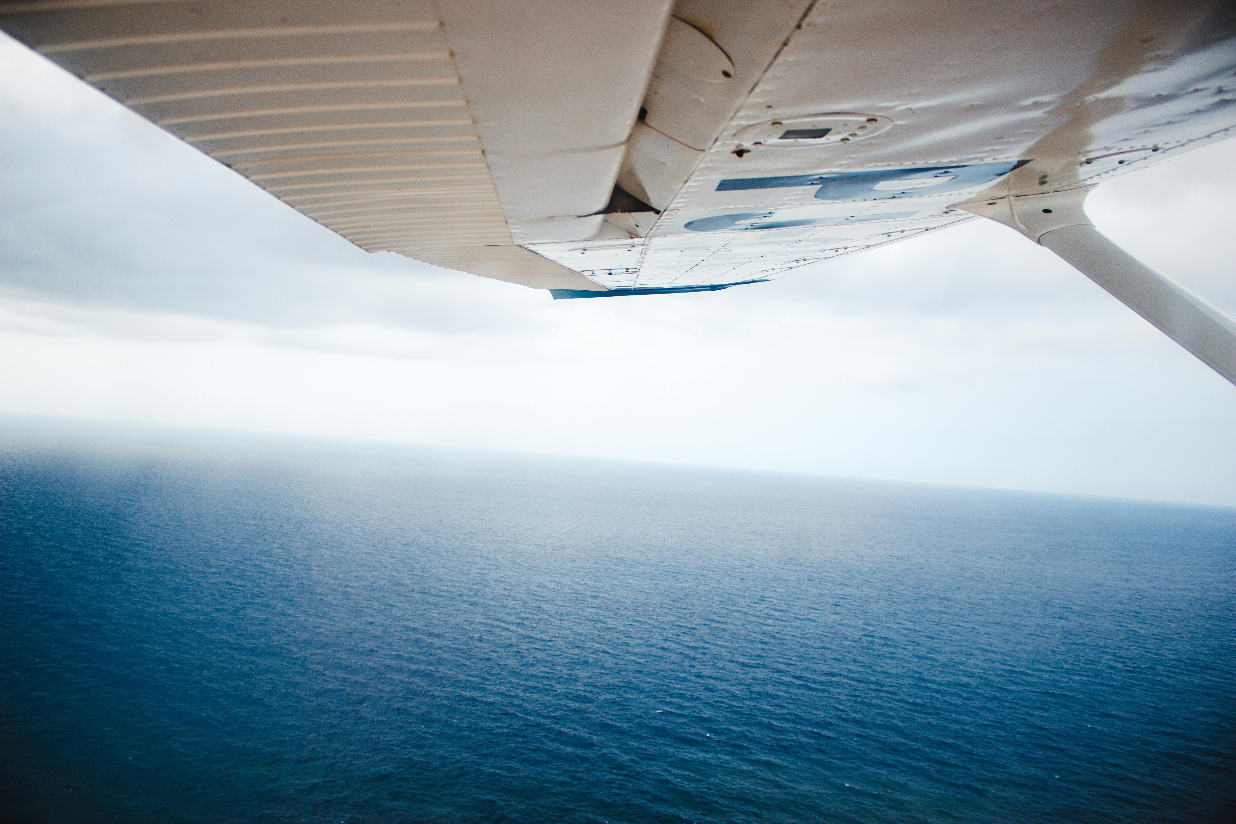 aerial photography of plane flying above ocean