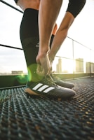 Close-up of hands tying cleats before a competitive training session.