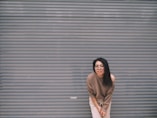 woman leaning on gray garage door
