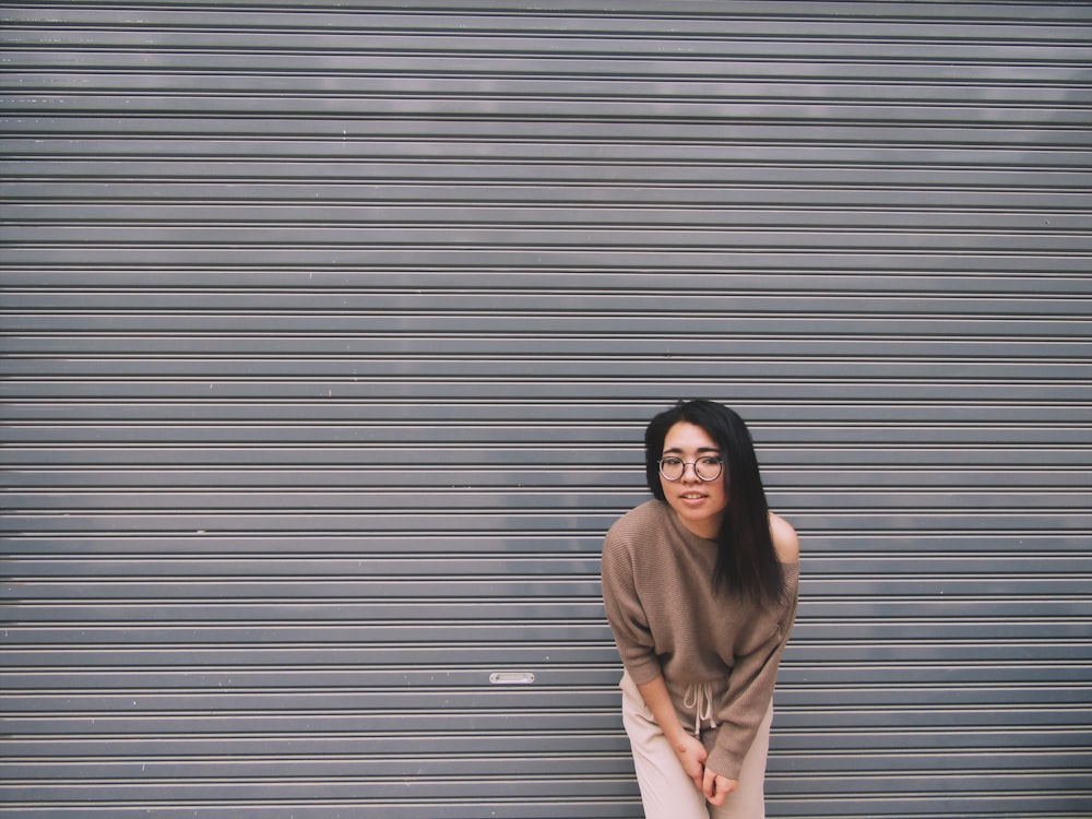 woman leaning on gray garage door