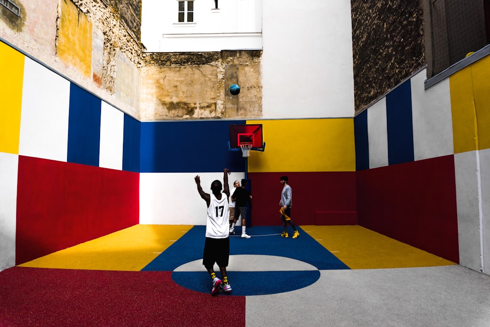Hombre jugando baloncesto dentro de una cancha multicolor