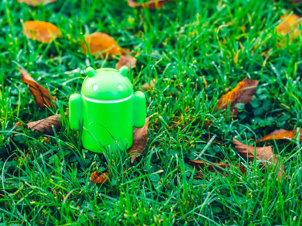 grünes Android-Roboterspielzeug auf Gras