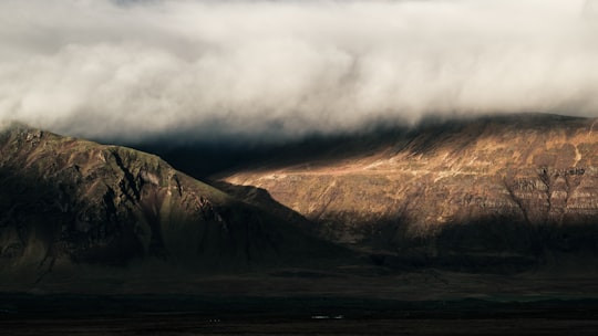 brown rocky mountain under white clouds in Snaefellsnes Iceland