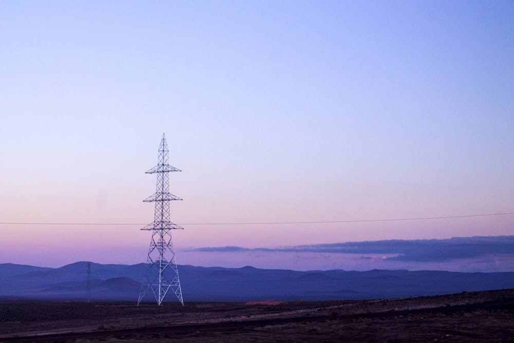 landscape photography of electricity pylon on field