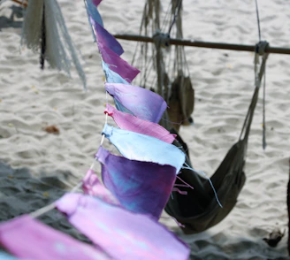 A vibrant display of colorful dog bandanas fluttering in a gentle sea breeze on a sunny beach.