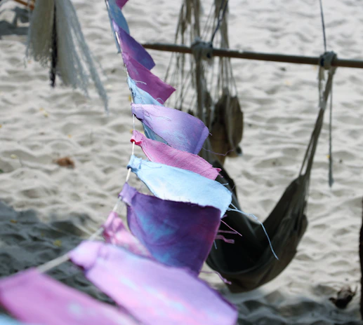 A vibrant display of colorful dog bandanas fluttering in a gentle sea breeze on a sunny beach.