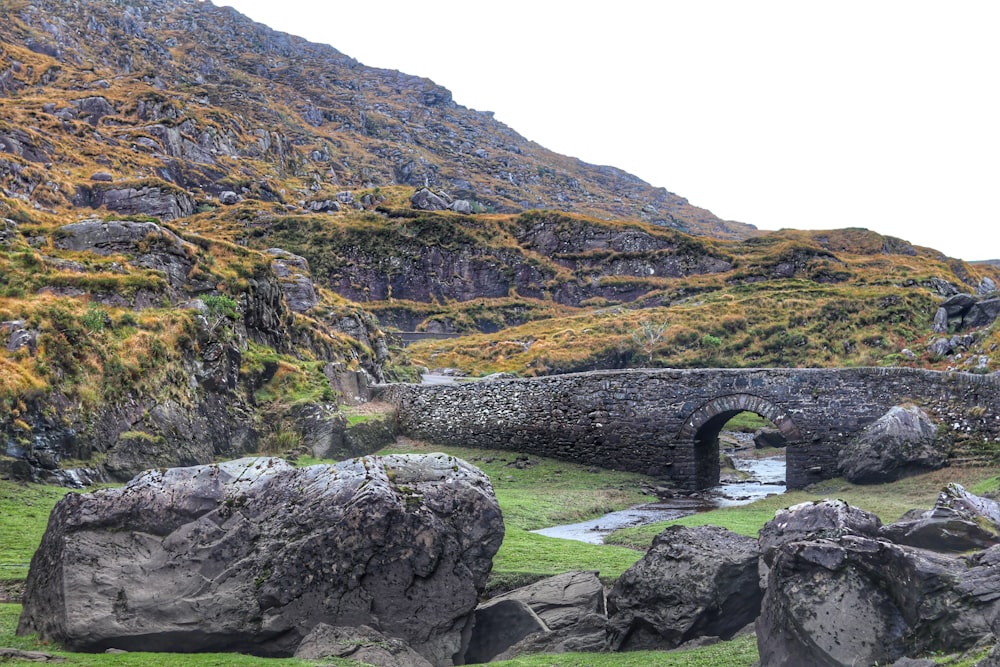 Puente de hormigón gris junto a una montaña