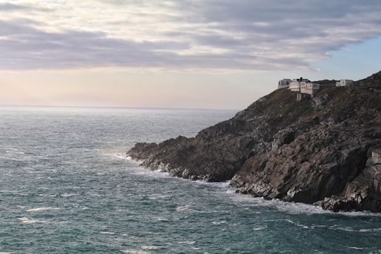 white house on cliff near body of water under cloudy sky at daytime in Mizen Head Ireland