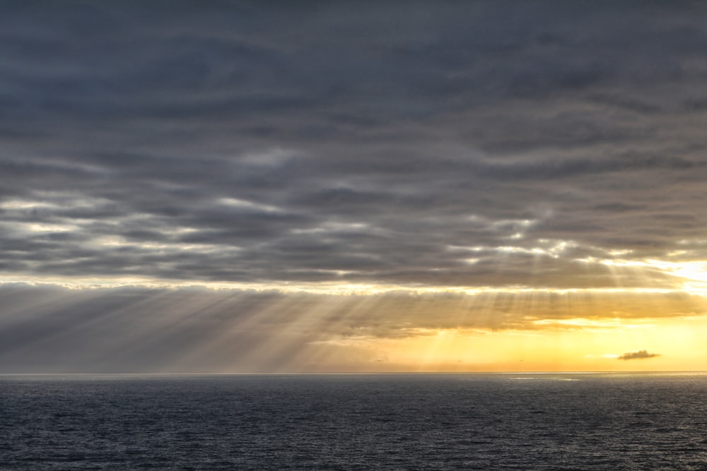 sun rays through clouds over the horizon