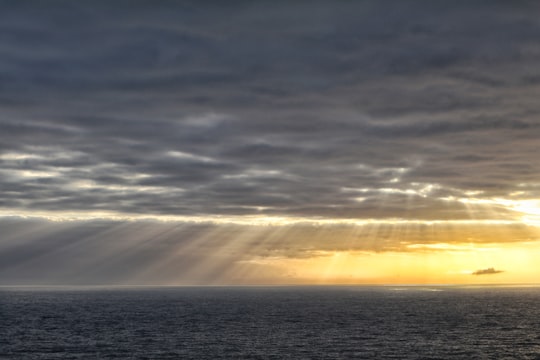 sun rays through clouds over the horizon in Mizen Head Ireland