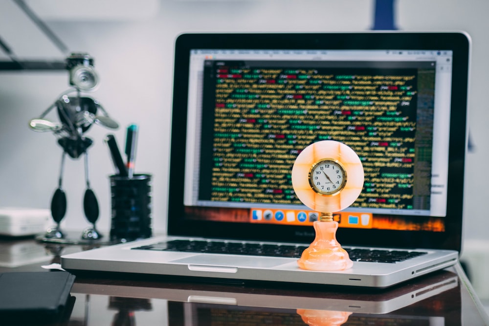 round beige analog table clock on MacBook Pro