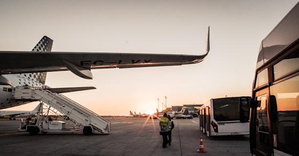 A busy airport ground crew assisting a plane during sunset at Sudanese airport.
