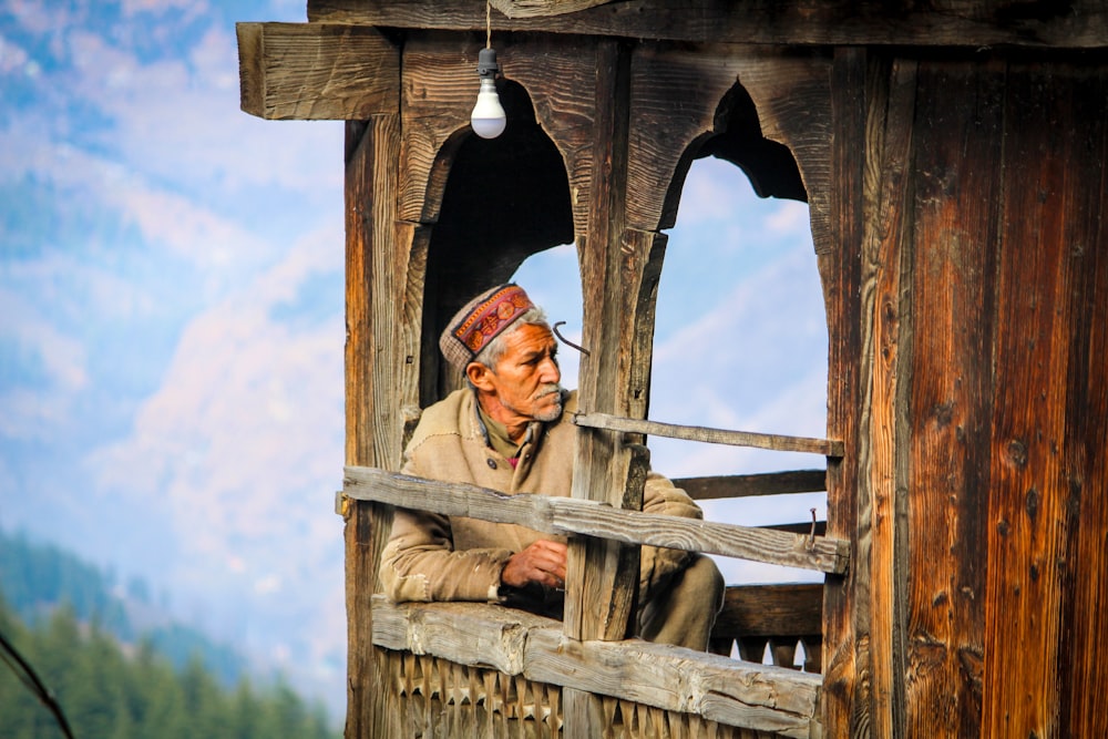 sitting man inside brown wooden building