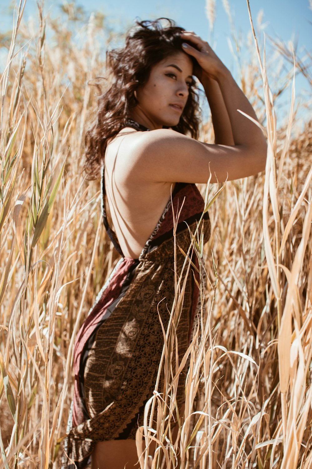 woman standing on brown long grass field