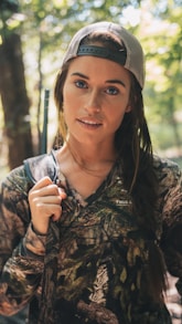 woman wearing realistic camouflage top and carrying rifle