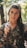 woman wearing realistic camouflage top and carrying rifle