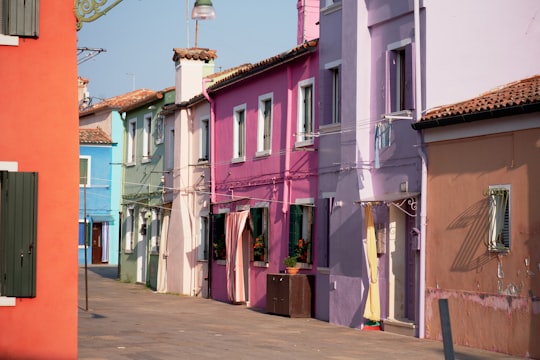 pink, purple, brown, and teal concrete buildings in Burano Italy