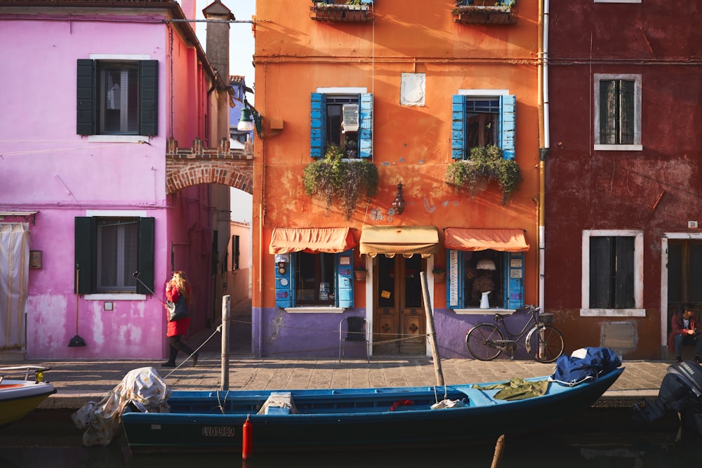 blue boat on river near orange building