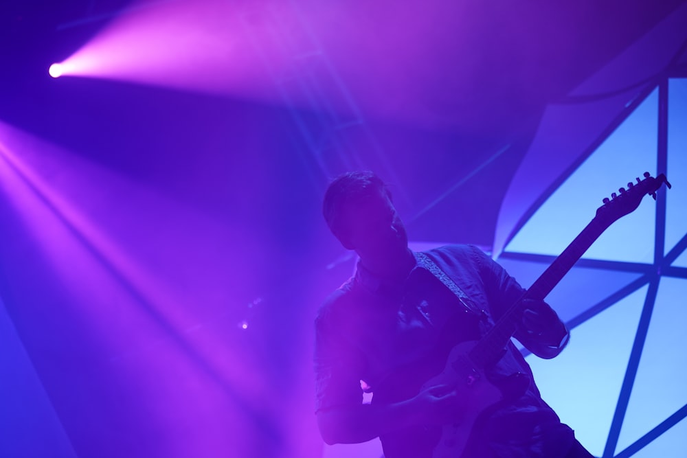 man playing guitar on stage