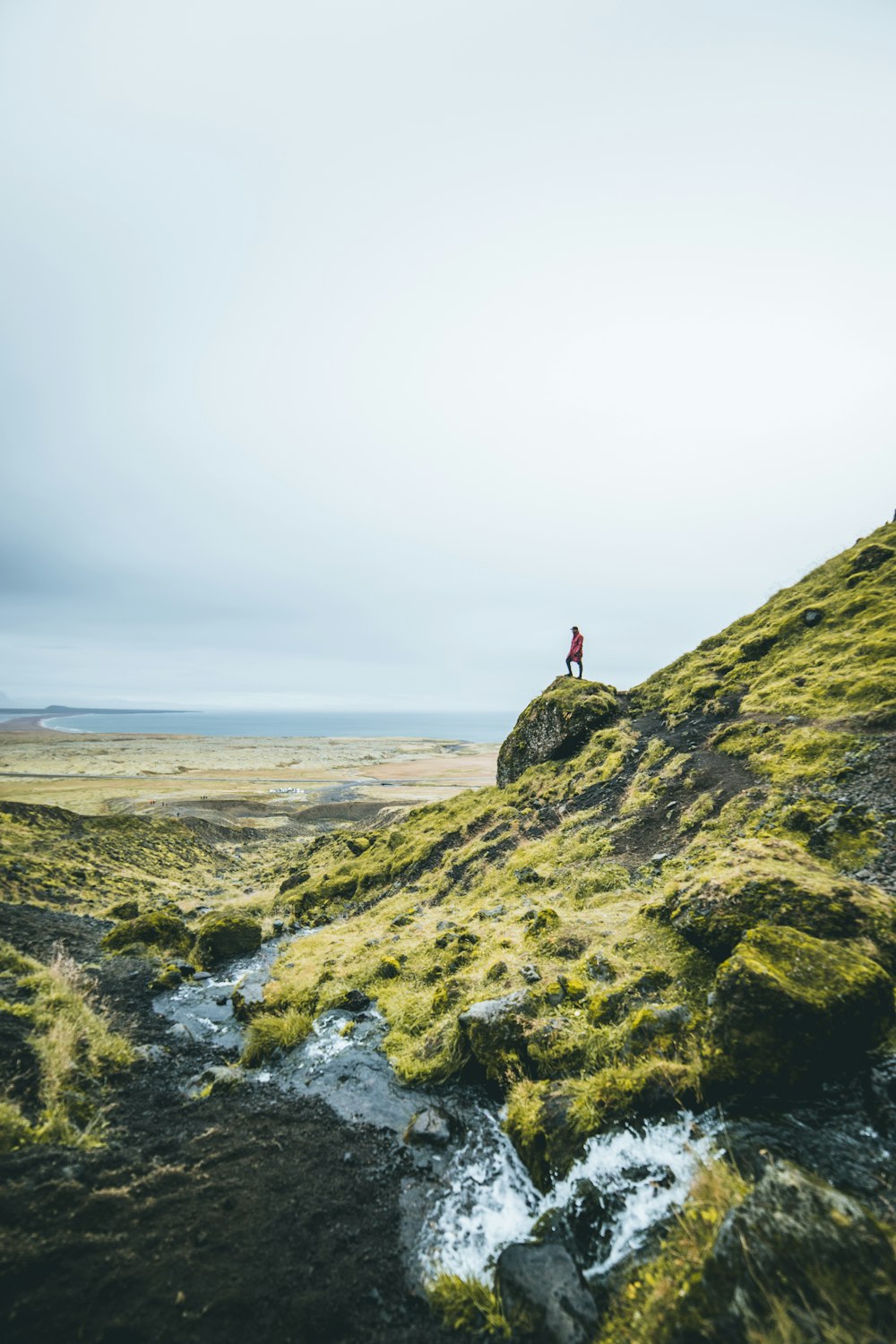 man standing on green mountain during daytime