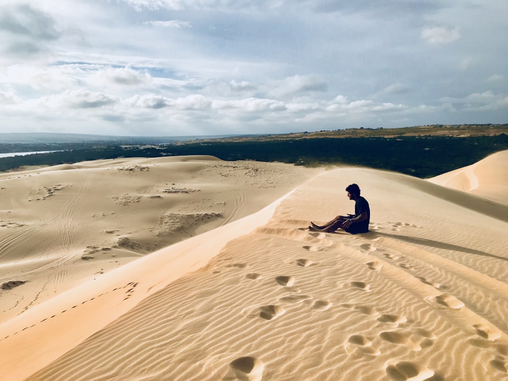 Person, die auf Sand sitzt