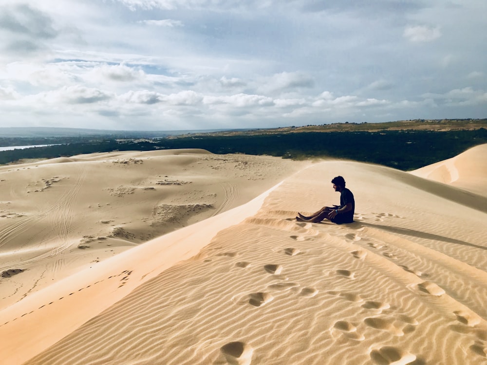 person sitting on sand