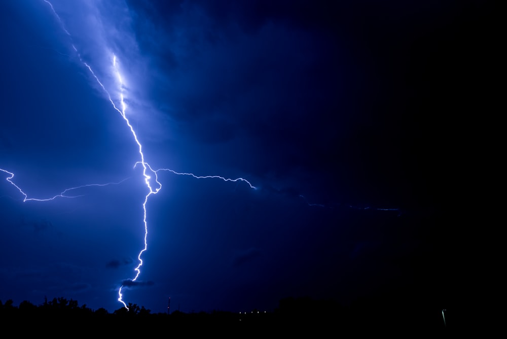 lightning bolts striking a body of land during night