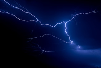Close-up of vivid yellow lightning bolts striking against a deep black background, illuminating the scene with electric energy.