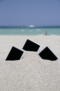 three photo frames on seashore near sea