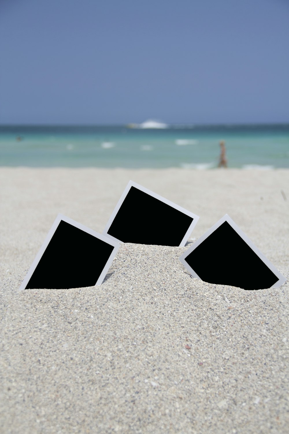 three photo frames on seashore near sea