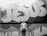 grayscale photography of a man standing in front of a Jesus graffiti