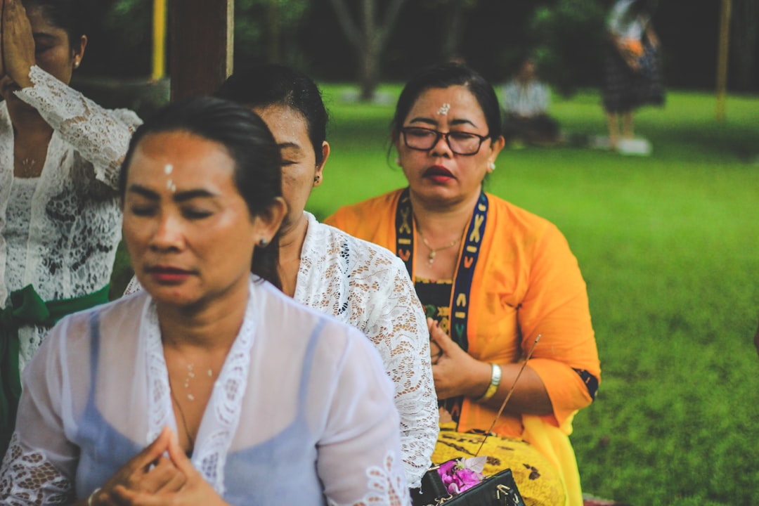 four people closing eyes while on grass