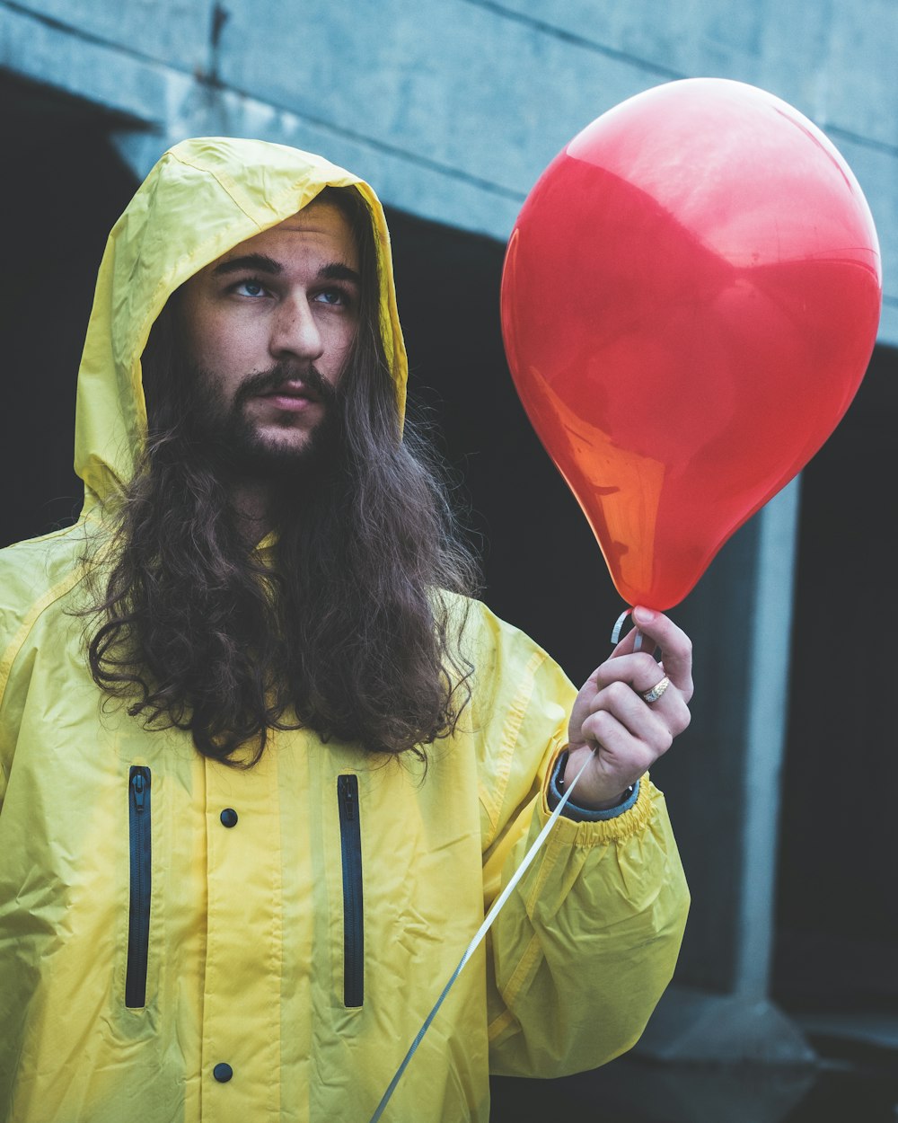 man holding red balloon