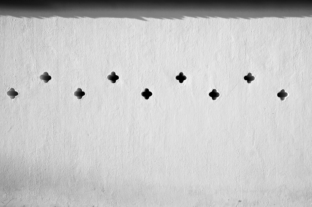 a black and white photo of a wall with holes in it