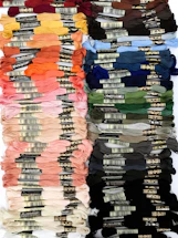 Close-up of colorful silk threads arranged neatly on a wooden table.