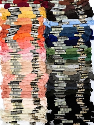 A close-up of colorful embroidery threads arranged neatly on a wooden table.